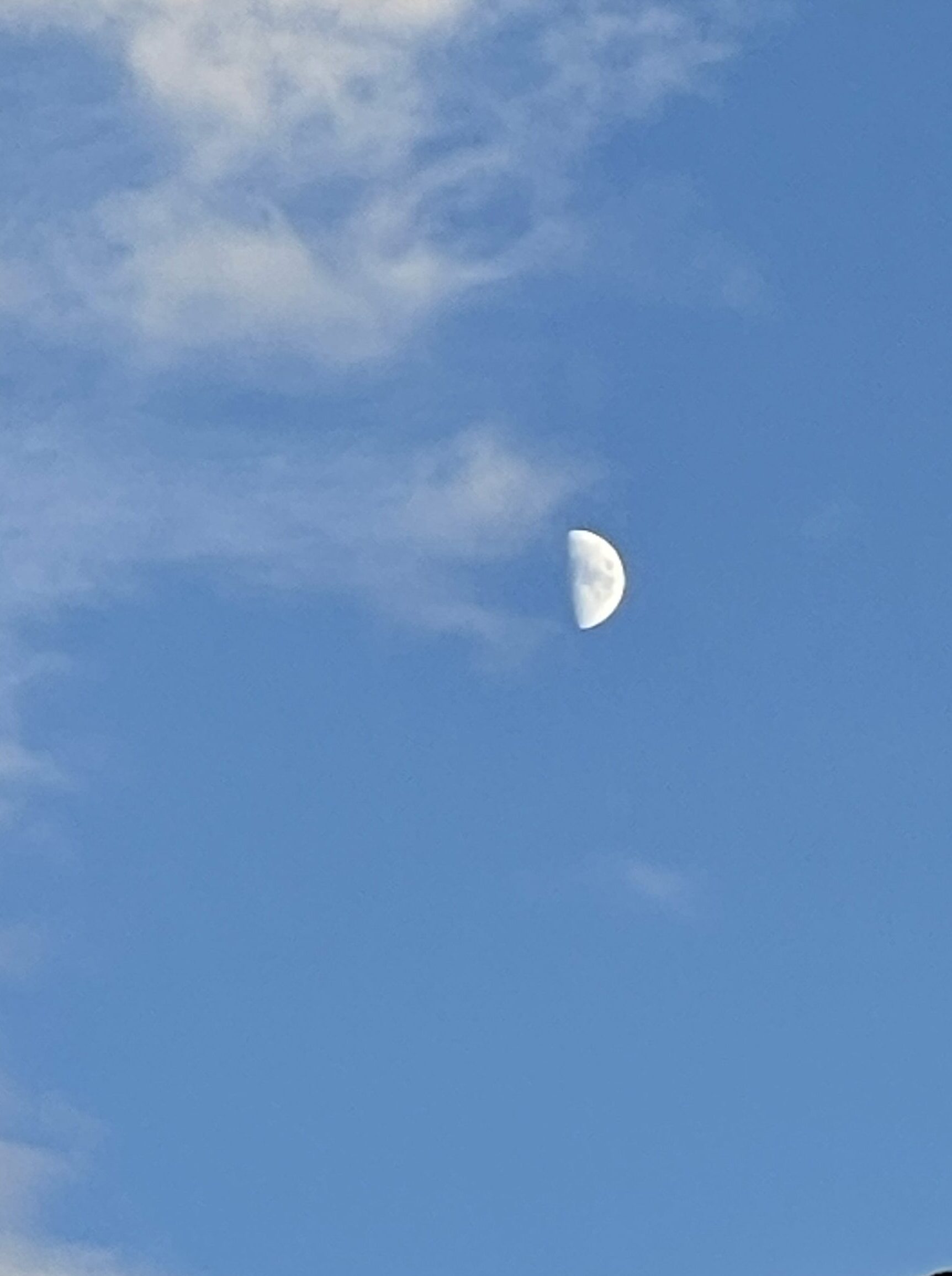 Half Moon and clouds in a medium blue sky - Astrology